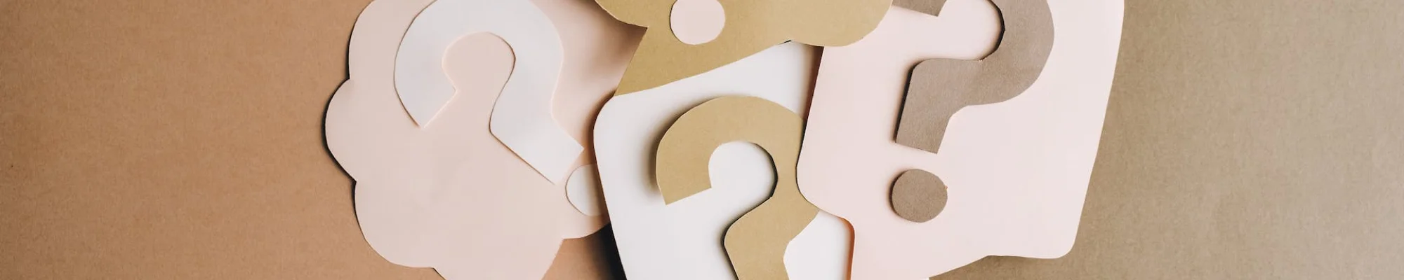 light pink, beige and white paper question signs